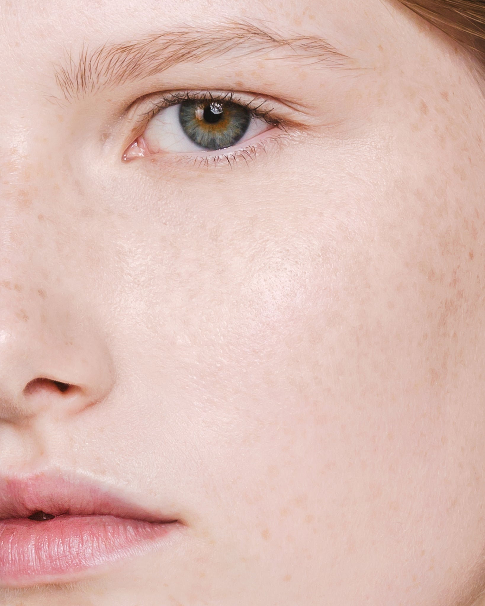 Model wearing MΓDARA Organic Skincare the concealer vanilla on A6100 concealer on skin; close-up portrait shows natural application results.