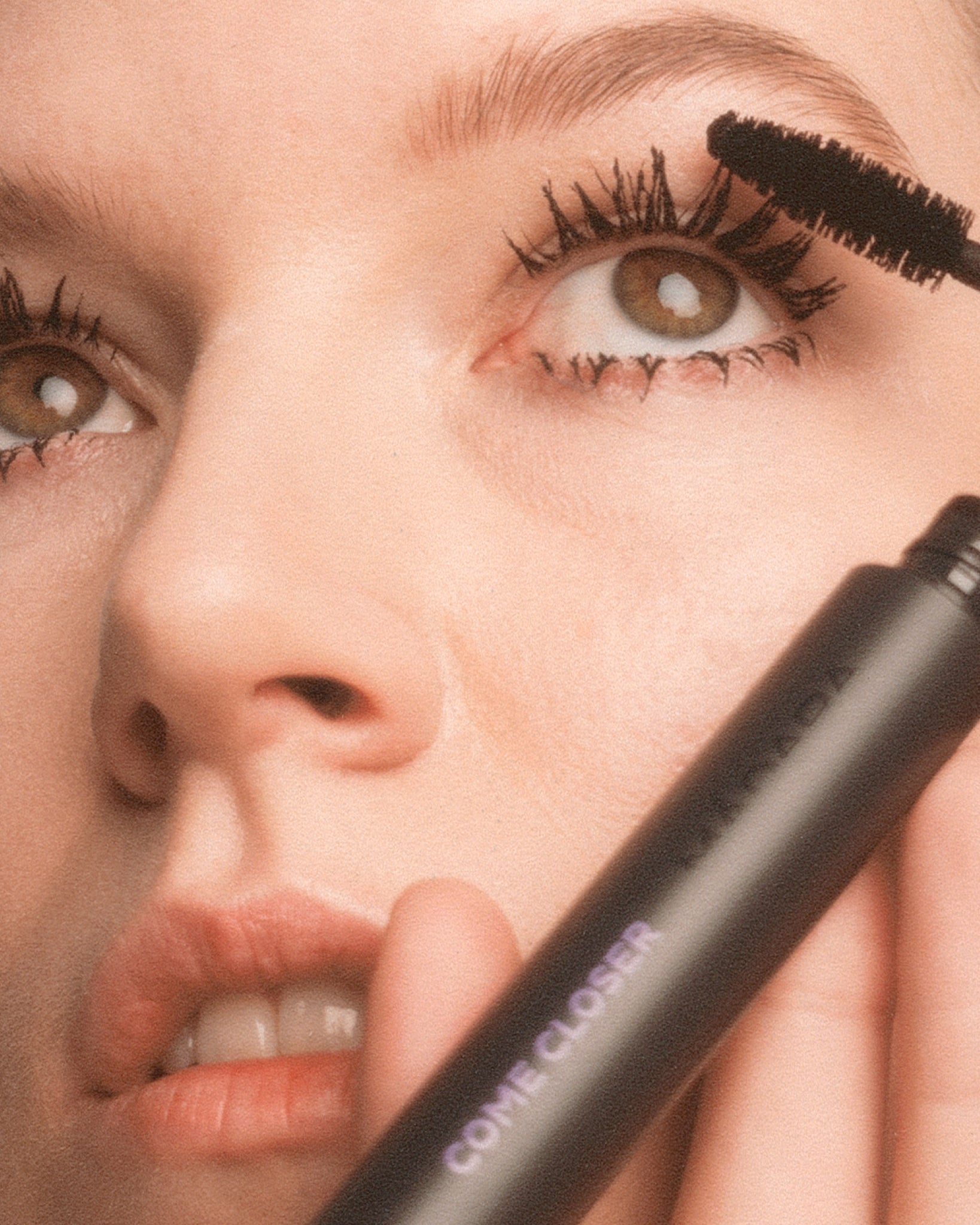 Model wearing MÁDARA Organic Skincare infinite lash mascara on A6602 on skin; close-up portrait shows natural application results.