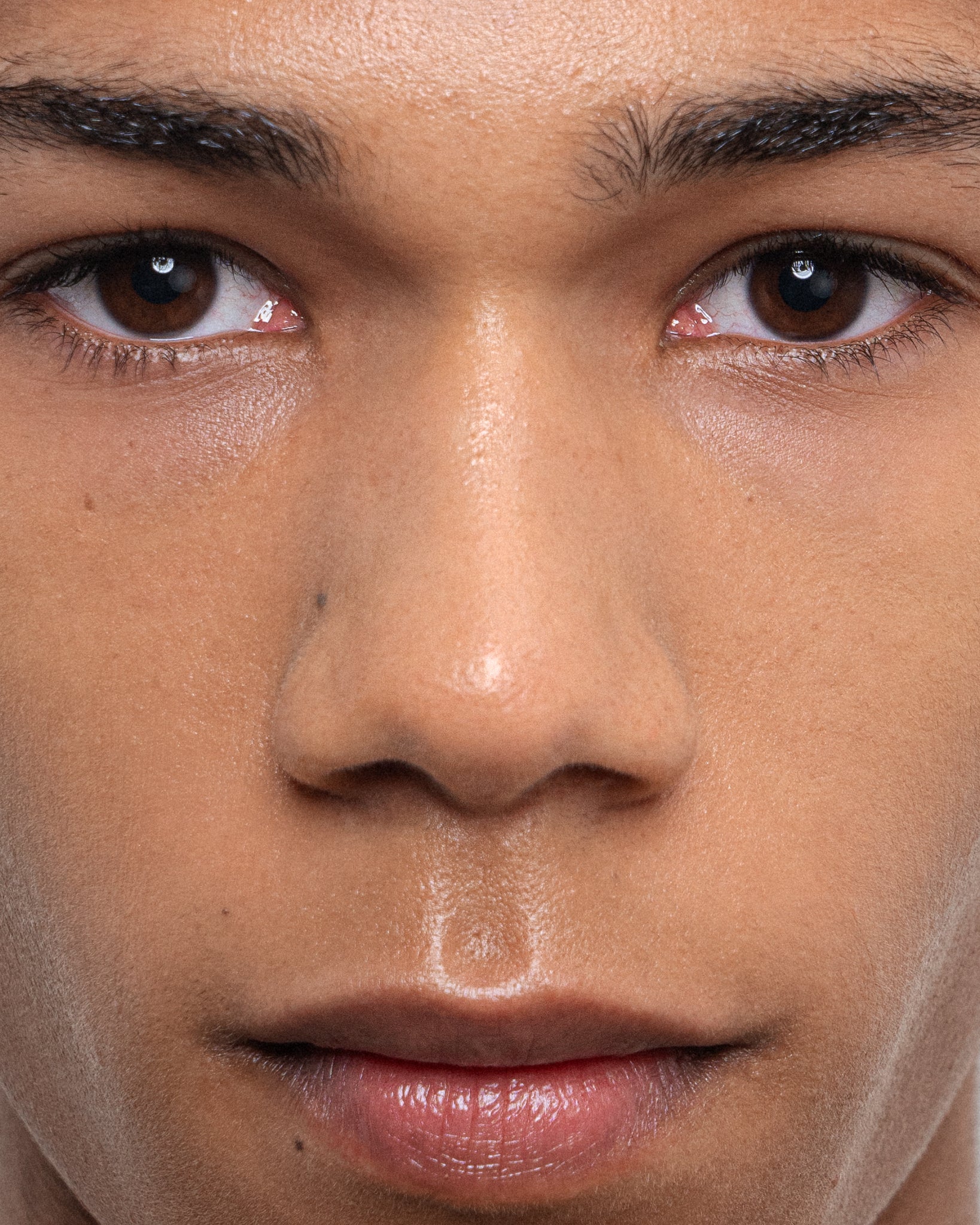 Model wearing MÁDARA Organic Skincare wild flower serum on A3514 serum on skin; close-up portrait shows natural application results.