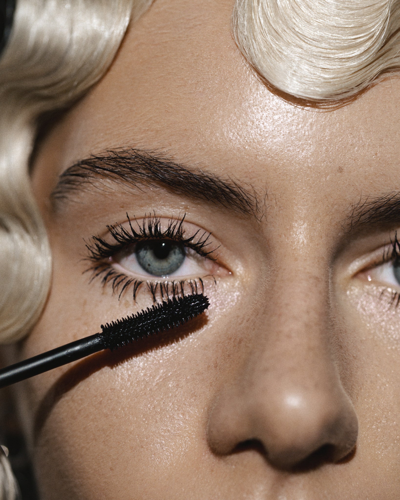 Model wearing MÁDARA Organic Skincare mascara on A0033 on skin; close-up portrait shows natural application results.