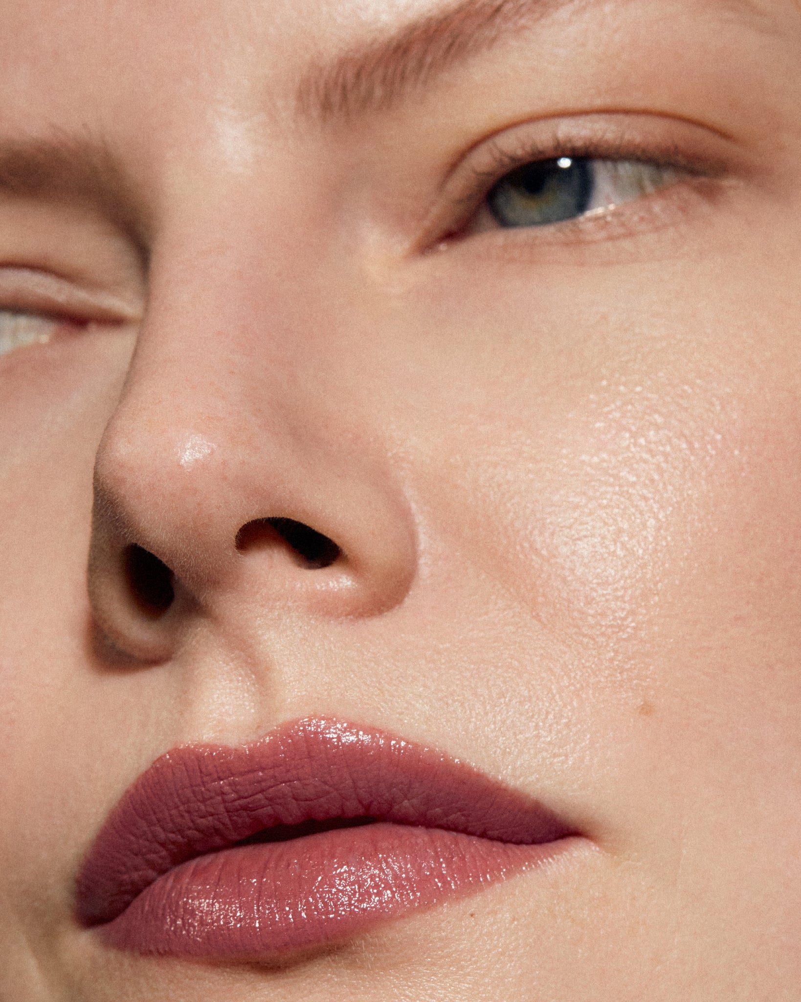 Model wearing MÁDARA Organic Skincare satin shine lipstick charisma on A6503 on skin; close-up portrait shows natural application results.